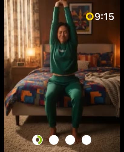 Un video de Wakeout de un minuto en el Apple Watch: una mujer estira los brazos hacia arriba junto a su cama