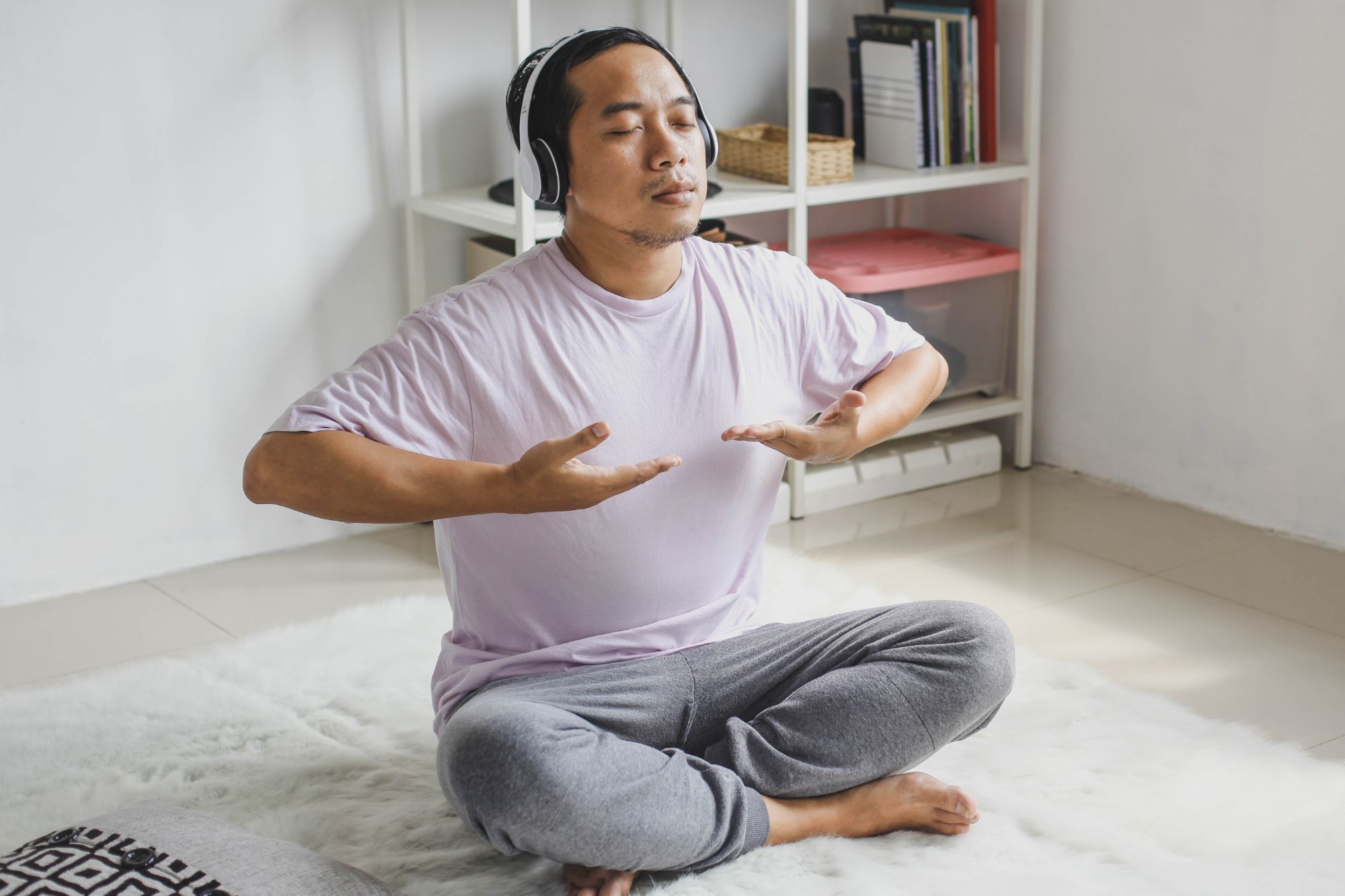 A man in lotus position breathing to a relaxing tune