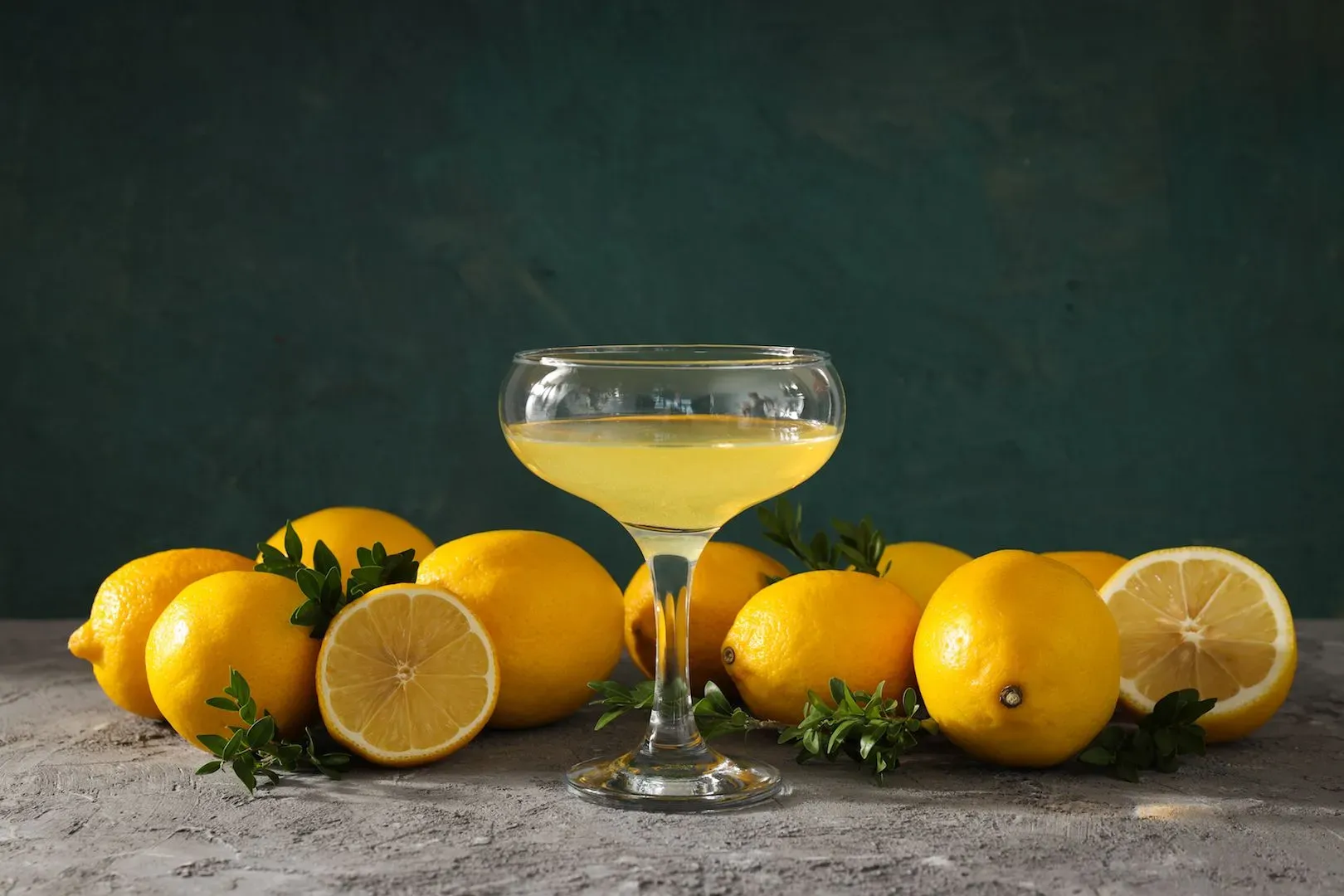 A lemon juice in a champagne glass with lemons dropped on sides