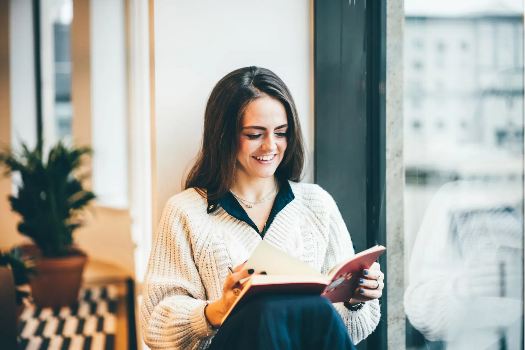 A woman happily reading a book at work