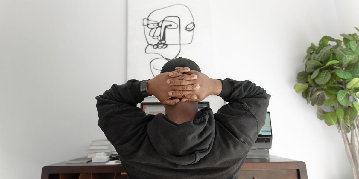 A person stressed at work with hands behind the head, feeling overwhelmed
