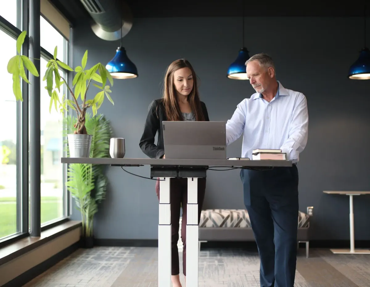 Business employess at a standing desk in a ergonomically designed workplace